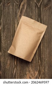 Brown Kraft Paper Pouch Bag On Wood Table. Mock-up Template For Design.