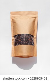 Brown kraft paper pouch bags with coffee beans top view with shadow isolated on white background. Packaging for foods and goods template mockup.Pack with clasp and window for tea leaves weight product