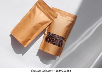 Brown kraft paper pouch bags with coffee beans top view with shadow isolated on white background. Packaging for foods and goods template mockup.Pack with clasp and window for tea leaves weight product - Shutterstock ID 1839213553