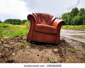 Brown Leather Armchair Standing By A Concrete Slab Road.