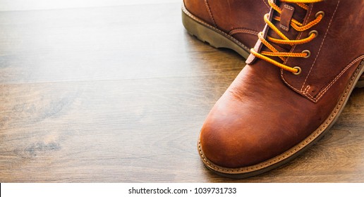 brown leather boots shoes on the brown wooden table background.with copy space. - Shutterstock ID 1039731733