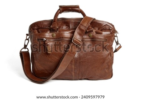 Brown leather briefcase with handles and strap. Vegetable tunned leather bag isolated on white background.