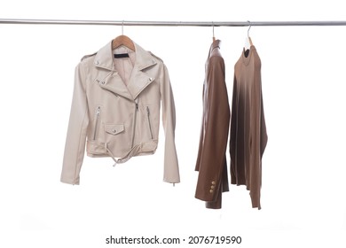 Brown Leather Coat ,jacket , Brown Sweater Hanging On Wooden Clothes Rack Isolated Over White Background 

