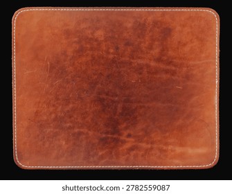 Brown leather computer mouse pad with stitched border, worn surface, rounded corners, isolated on black background. Natural background for office desk, workspace, product mockup featuring mouse pad