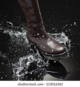 brown leather female boot splashing water