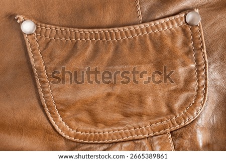 Brown leather jacket patch pocket closeup as a background