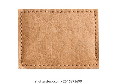 Brown leather patch closeup. Empty stitched label isolated on white background. Blank textured tag. Real leather surface with natural wrinkles. Sewing detail for jeans. Vintage fashion element mockup.