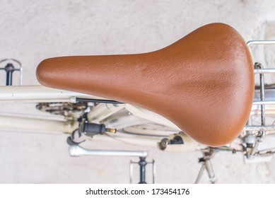 Brown leather saddle of bicycle from top view.