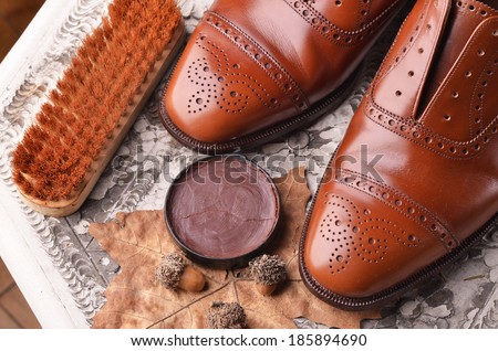 Brown leather shoes on table with polishing equipment