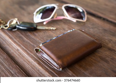 Brown leather wallet from the back party on wooden table, Old leather wallet on wood table