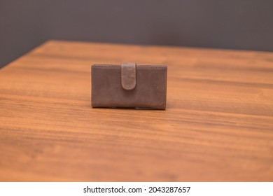 Brown Leather Wallet On The Wooden Table. Unisex Wallet.