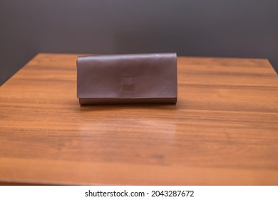 Brown Leather Wallet On The Wooden Table. Unisex Wallet.