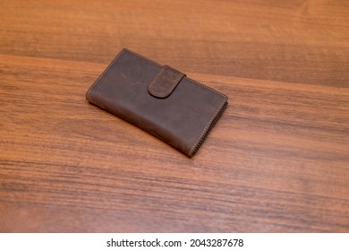 Brown Leather Wallet On The Wooden Table. Unisex Wallet.