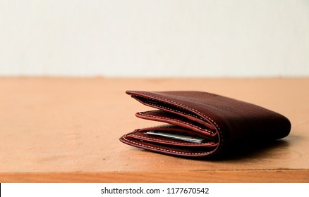 Brown leather wallet put on wooden table top
