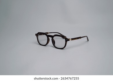 Brown leopard pattern square sunglasses, facing left sideways isolated on white background. Minimalist view of the glasses at a 45 degree angle with space for text.