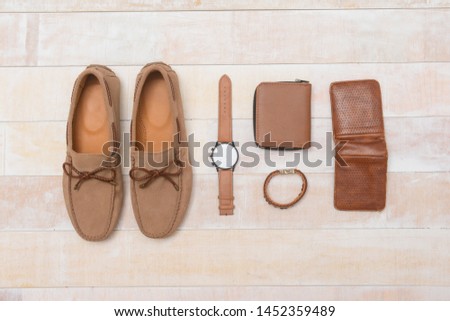 brown loafers shoes with watch, purse , Bracelet, on wooden background


