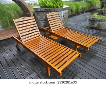 A brown lounge chair made from teak wood which is usually used at the beach, swimming or spa.