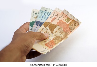 Brown Man Holding Multiple Pakistani Currency Notes On White Background