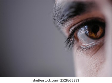 A brown man's eye looks into the camera. - Powered by Shutterstock