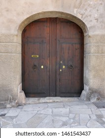Brown massive wooden door in old-style spanish stone building