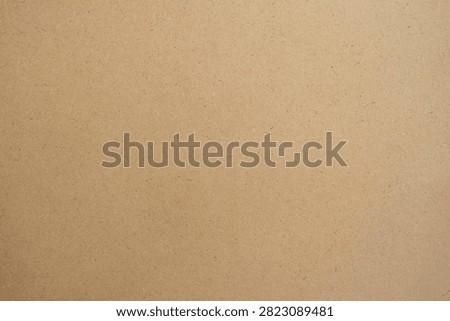 Brown MDF board texture background. Close up of smooth cardboard or craft paper surface.