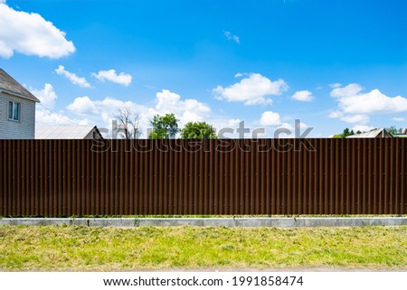Brown metal corrugated fence against the sky. Texture of profiled metal.