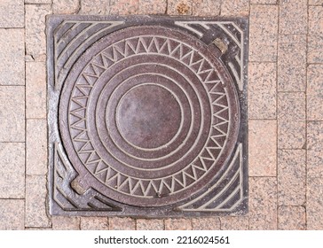 Brown Metal Manhole Cover Square Neck Edging On The City Cobblestone Street