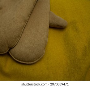 Brown Mittens On A Yellow Scarf, Isolated