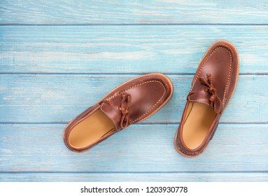 Brown Oil Pull Up Leather Men’s Loafer Shoes Isolated On A Blue Wooden Background. Fashion Advertising Shoes Photos.