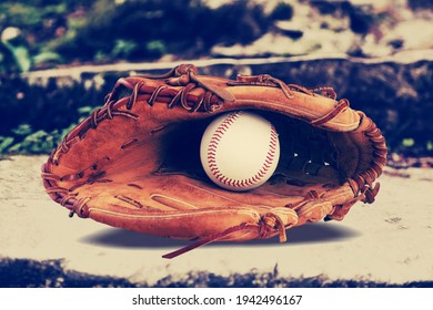 Brown old baseball glove with the ball on the desk