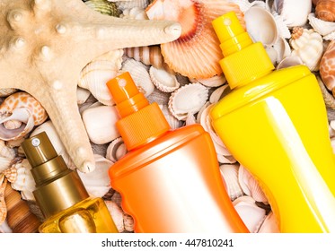 Brown, Orange And Yellow Containers Of Cosmetic Sunscreen Products With Variety Of Shells And Starfish. Skin Care Cosmetics Containing Sun Protection Factor For Safe Tan