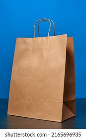 A Brown Paper Bag With Handles On A Blue Background. ECO Bag. Craft Paper Bag. Recycled Paper. Environmentally Friendly Bags.