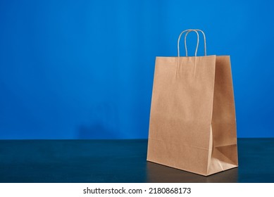 A Brown Paper Bag With Handles On A Blue Background. ECO Bag. Craft Paper Bag. Recycled Paper. Environmentally Friendly Bags.