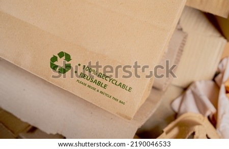 Brown paper bag that is 100% recyclable and reusable with green recycling symbol. eco-friendly and save the world concept
