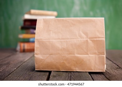 Brown Paper Lunch Bag And Books In The Background