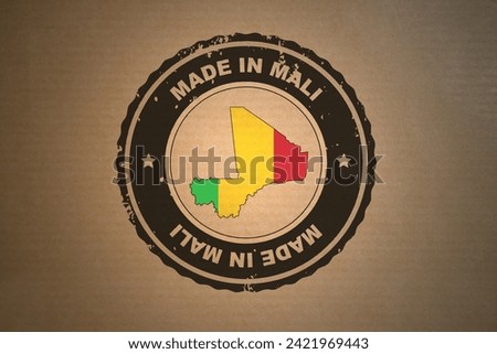 Brown paper with in its middle a retro style stamp Made in Mali include the map and flag of Mali.