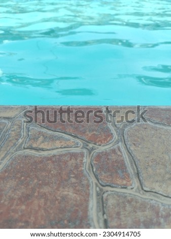A brown pattern ceramic like a sand and blue clean water like a sea water in swimming pool.