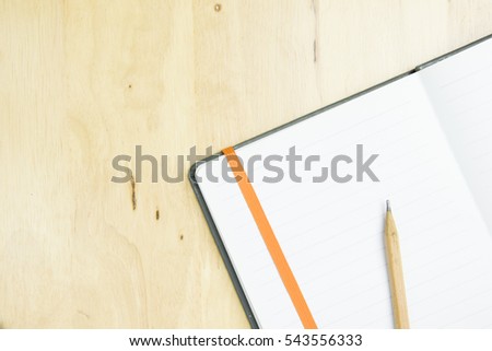 brown pencil with notebook on work space wooden. top view, flat lay concept.