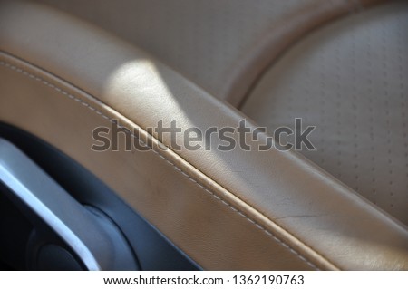 Brown perforated leather seats with close up details in the seat levers and setups, supercar interior
