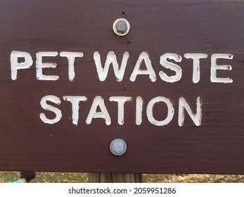 Brown Pet Waste Station Sign With White Letters At Park