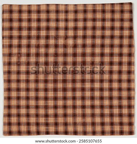 Brown plaid fabric with a checkered pattern. The plaid design features intersecting lines. The fabric's checkered style adds a classic plaid look. Vintage art.