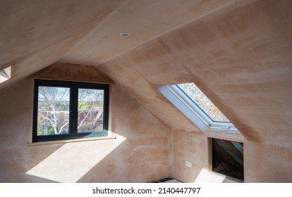 Brown plastered walls in the property, preparation for the paint. Loft conversion with roof windows selective focus - Shutterstock ID 2140447797