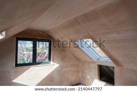 Brown plastered walls in the property, preparation for the paint. Loft conversion with roof windows selective focus