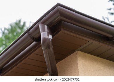 Brown Plastic Gutter System Against Sky, Roof Overhang