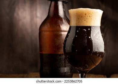 Brown porter on dark rustic background, english dark beer.