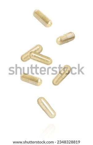 Brown powder herbal medicine capsule flying in the air isolated on white background. 
