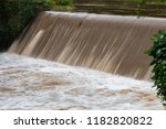 Brown rain runoff from Hurricane Florence rushes over the spillway on the Readdies River in North Wilkesboro, NC.