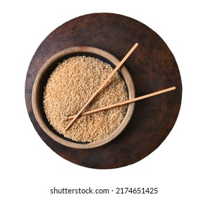 Brown Rice And Chop Sticks On Round Wood Table, Isolated On White - Overhead View.