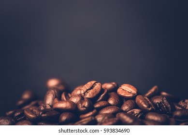 Brown roasted coffee beans, seed on dark background. Espresso dark, aroma, black caffeine drink. Closeup isolated energy mocha, cappuccino ingredient.