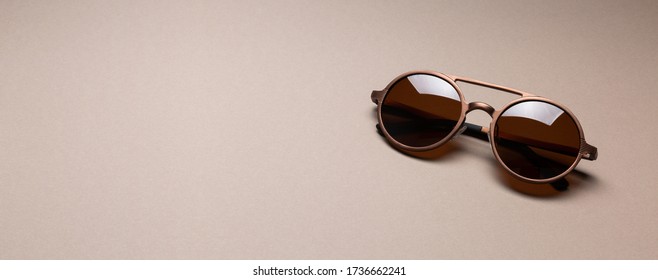 Brown Round Bronze Color Frame Sunglasses On Paper Minimal Abstract Background. Male Summer Fashion Concept. Copy Space.